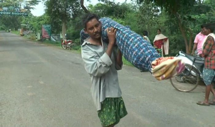 Dana Majhi with his wife over his shoulders wrapped in sheets